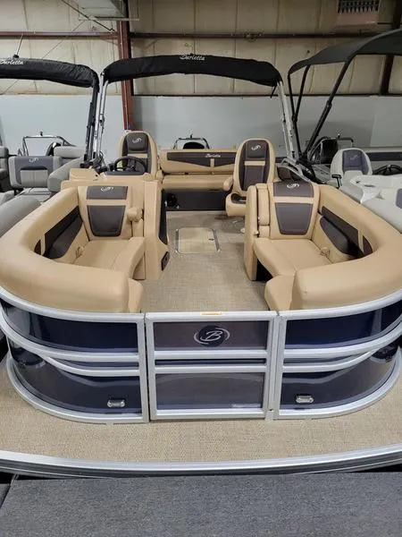 Slide: The Image of 2024 Barletta C22UC pontoon boat with beige seating and sleek design in a showroom. - 15