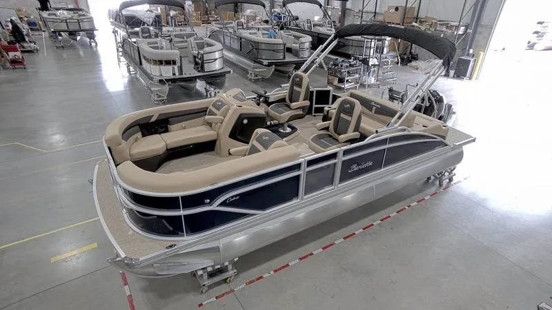 Slide: The Image of 2024 Barletta C22UC pontoon boat in showroom, featuring luxurious seating and sleek design. - 16