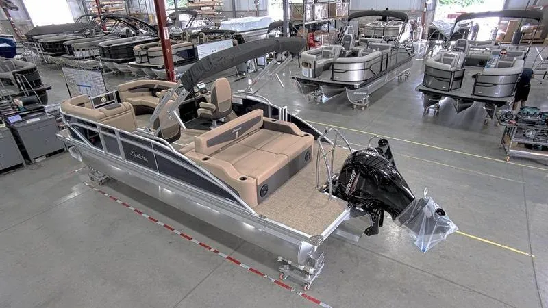 Slide: The Image of 2024 Barletta C22UC pontoon boat in a showroom, featuring spacious seating and modern design. - 19