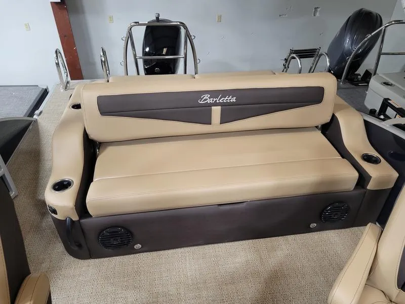 Slide: The Image of 2024 Barletta C22UC boat seating with beige and brown upholstery, featuring cup holders and speakers. - 7