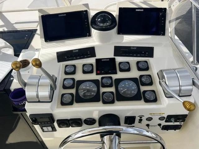 Slide: The Image of Control panel of a 2003 Carolina Classic 28 boat with gauges and navigation screens. - 12