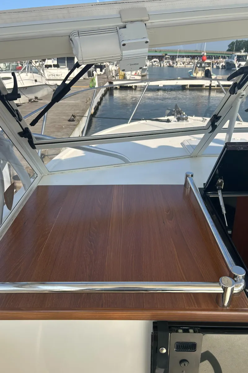 Slide: The Image of 2003 Carolina Classic 28 boat with wooden deck, docked at marina. - 13