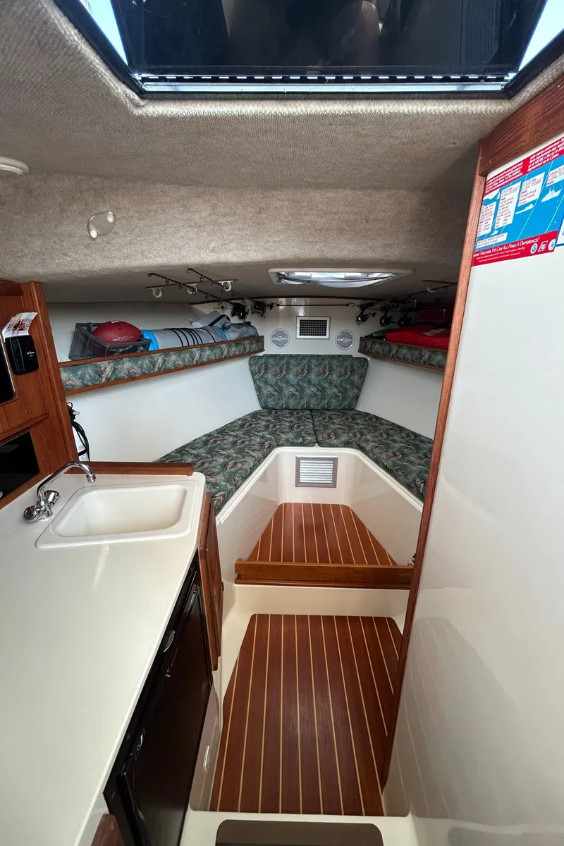 Slide: The Image of 2003 Carolina Classic 28 cabin interior with wood flooring and compact kitchenette. - 30