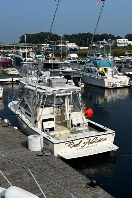 Slide: The Image of 2003 Carolina Classic 28 boat docked in a marina, surrounded by other vessels. - 4