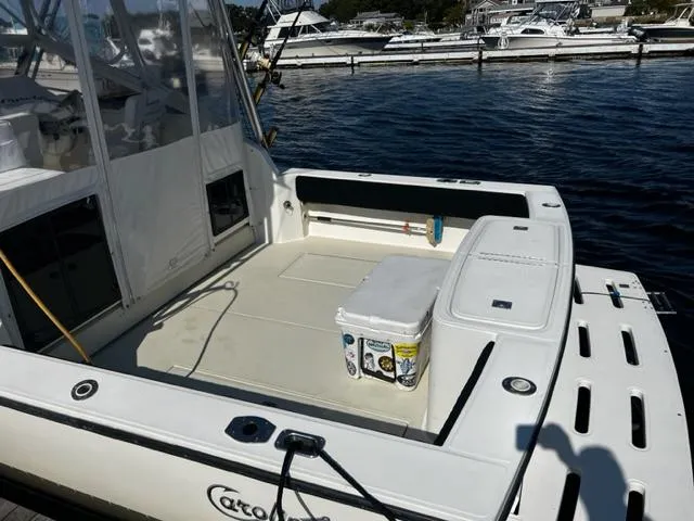 Slide: The Image of 2003 Carolina Classic 28 boat deck with seating and storage, docked by the water. - 6