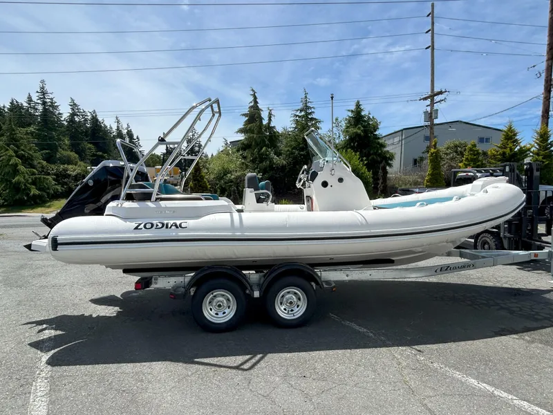 Slide: The Image of 2024 Zodiac Medline 6.8 boat on trailer, parked outdoors under clear sky. - 14