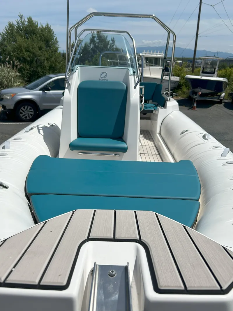 Slide: The Image of 2024 Zodiac Medline 6.8 boat with teal seating and sleek design, parked outdoors. - 16