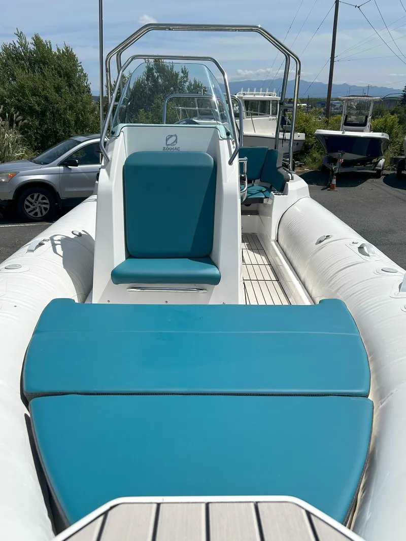 Slide: The Image of 2024 Zodiac Medline 6.8 boat with teal seating, docked outdoors. - 4