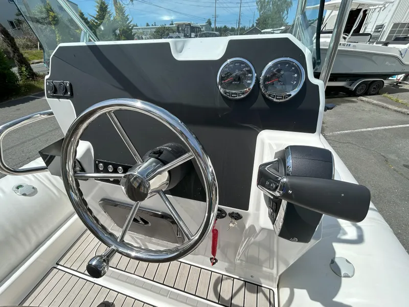 Slide: The Image of 2024 Zodiac Medline 6.8 boat dashboard with steering wheel and gauges. - 6