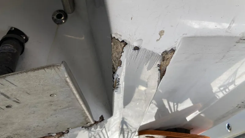 Slide: The Image of Damaged hull of a 2006 Cobalt 263 boat showing cracks and exposed material. - 11
