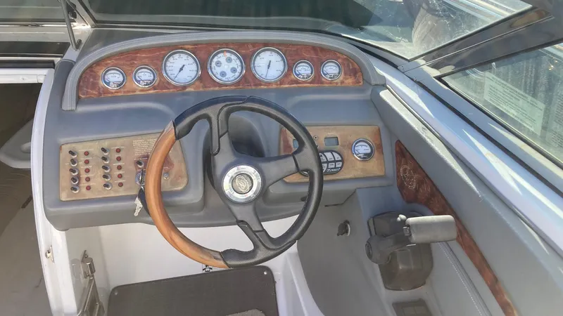 Slide: The Image of 2006 Cobalt 263 boat dashboard with wood accents and steering wheel. - 23