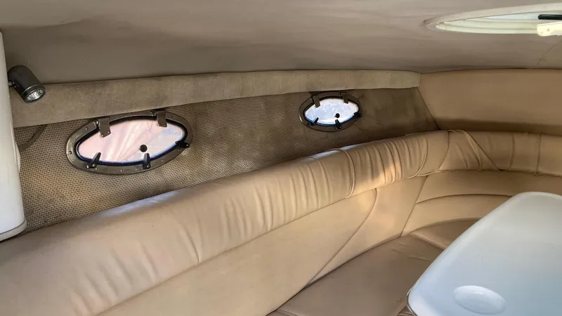 Slide: The Image of Interior cabin of a 2006 Cobalt 263 boat with beige seating and porthole windows. - 28