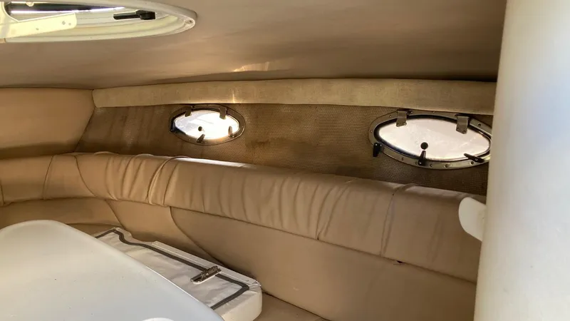 Slide: The Image of Interior cabin of a 2006 Cobalt 263 boat with beige seating and porthole windows. - 29