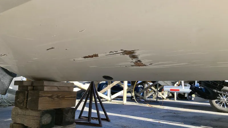 Slide: The Image of Damaged hull of a 2006 Cobalt 263 boat on blocks for repair. - 9