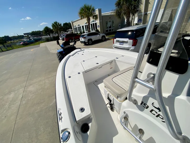 Slide: The Image of 2017 Mako 19 CPX boat parked outdoors near buildings and vehicles. - 11