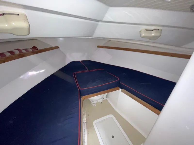 Slide: The Image of 2005 Hunt Yachts Harrier 25 cabin interior with blue cushions and white walls. - 11