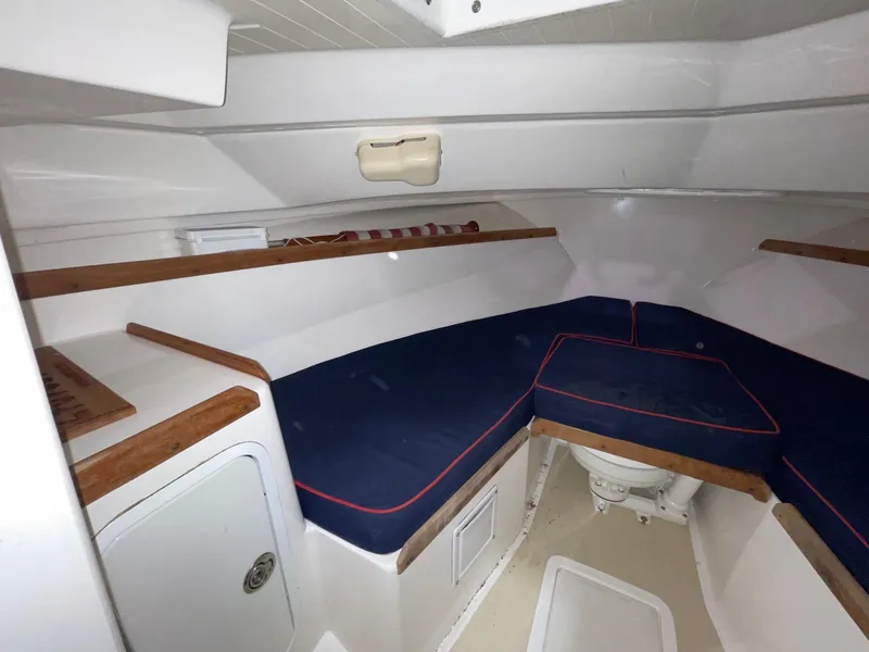 Slide: The Image of 2005 Hunt Yachts Harrier 25 cabin interior with blue cushions and wooden accents. - 12