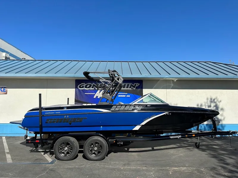 Slide: The Image of 2024 Sanger V215 SX boat in blue and black on a trailer. - 0