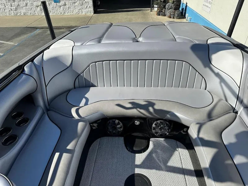 Slide: The Image of 2024 Sanger V215 SX boat interior with gray seating and built-in speakers. - 13