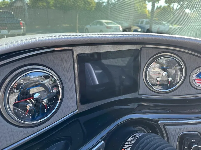 Slide: The Image of Dashboard of a 2024 Sanger V215 SX boat with analog gauges and digital display. - 17