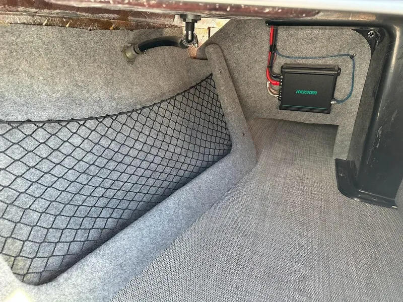 Slide: The Image of 2024 Sanger V215 SX boat storage compartment with netting and wiring. - 28