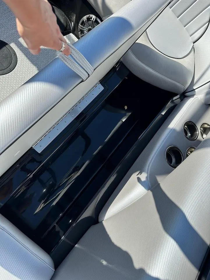 Slide: The Image of 2024 Sanger V215 SX boat interior storage compartment with gray seating. - 29