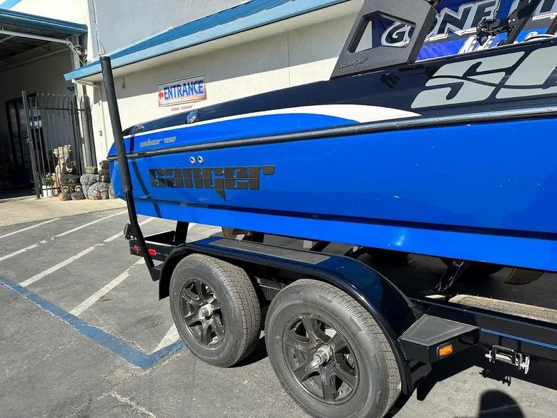 Slide: The Image of 2024 Sanger V215 SX boat on a trailer, blue and black color scheme. - 4