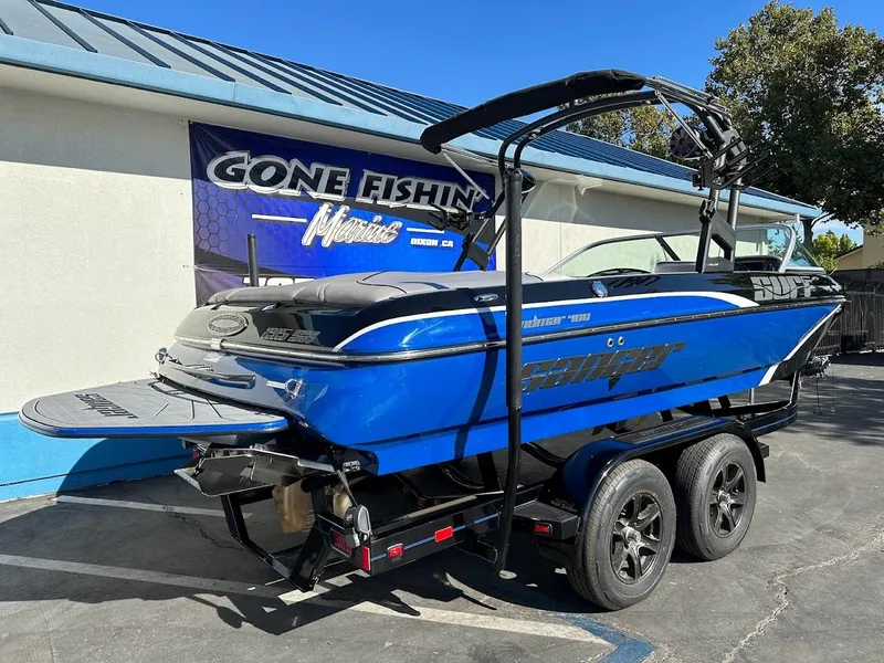 Slide: The Image of 2024 Sanger V215 SX boat in blue on a trailer outside a dealership. - 5