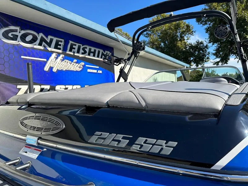 Slide: The Image of 2024 Sanger V215 SX boat at a dealership with Gone Fishing sign. - 8