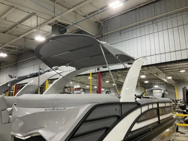 Slide: The Image of 2023 Bennington 25 RFBWA Tritoon with quad bench seating and modern interior design. - 8