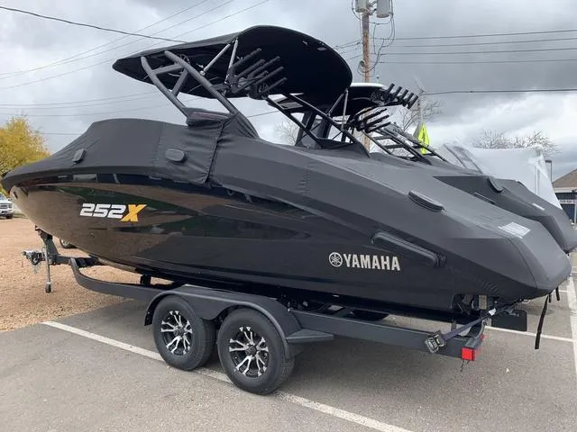 Slide: The Image of 2023 Yamaha Boats 252XE in black on trailer, side view. - 28
