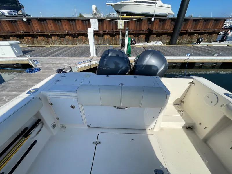 Slide: The Image of 2011 Pursuit 280 Center Console boat with twin outboard engines docked at a marina. - 11