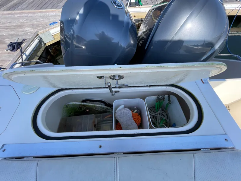Slide: The Image of Open storage compartment on a 2011 Pursuit 280 Center Console boat with fishing gear. - 16