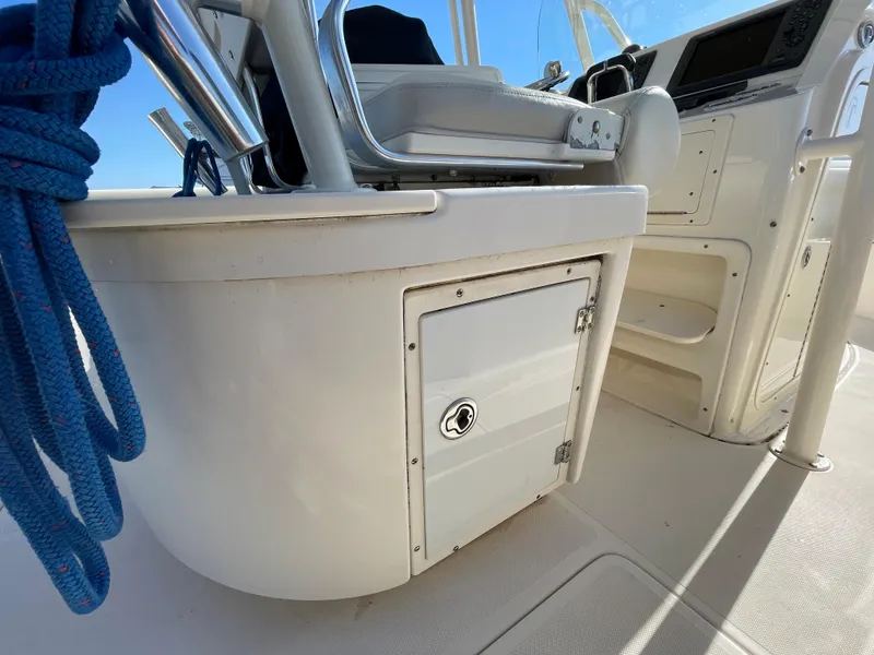 Slide: The Image of 2011 Pursuit 280 Center Console boat interior with storage compartment and blue rope. - 18