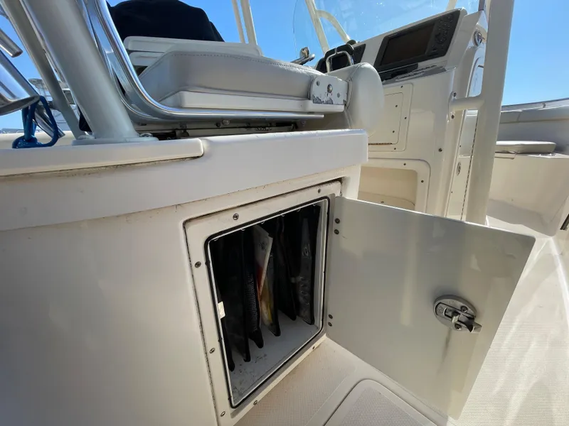 Slide: The Image of 2011 Pursuit 280 Center Console boat interior with open storage compartment. - 19