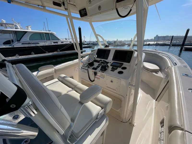 Slide: The Image of 2011 Pursuit 280 Center Console boat interior with helm station and seating at marina. - 20