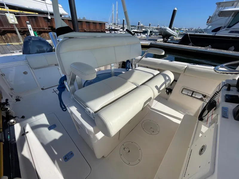 Slide: The Image of 2011 Pursuit 280 Center Console boat interior with white seating at a marina. - 22