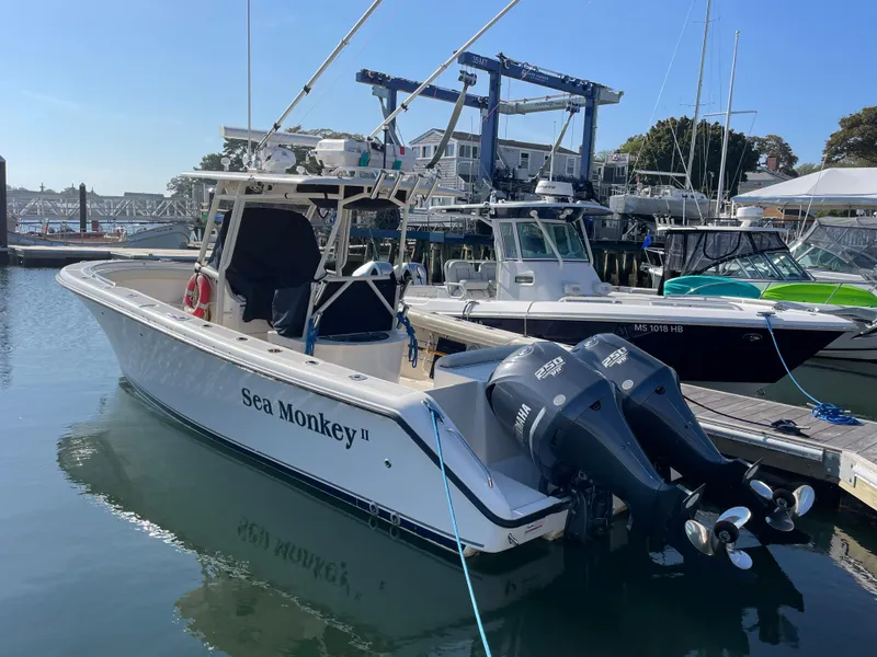Slide: The Image of 2011 Pursuit 280 Center Console boat docked at marina with twin outboard engines. - 3