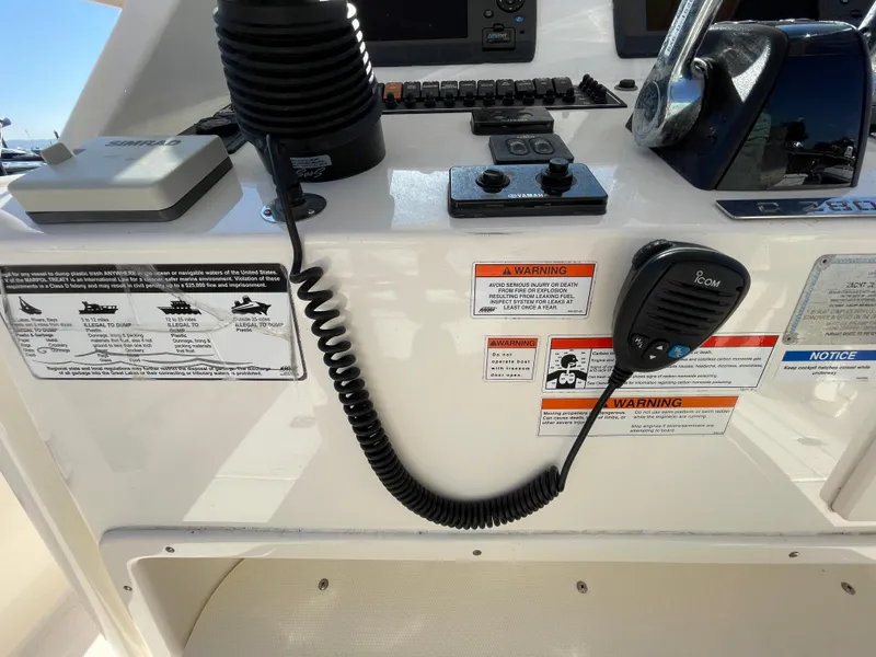 Slide: The Image of 2011 Pursuit 280 Center Console boat dashboard with controls and warning labels. - 32