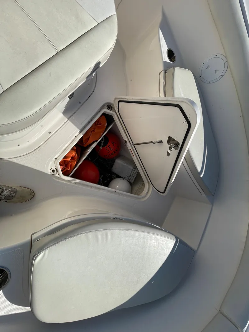 Slide: The Image of 2011 Pursuit 280 Center Console boat storage compartment with safety gear. - 39