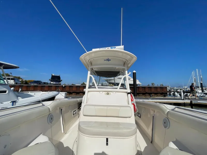 Slide: The Image of 2011 Pursuit 280 Center Console boat docked at a marina under clear blue sky. - 43