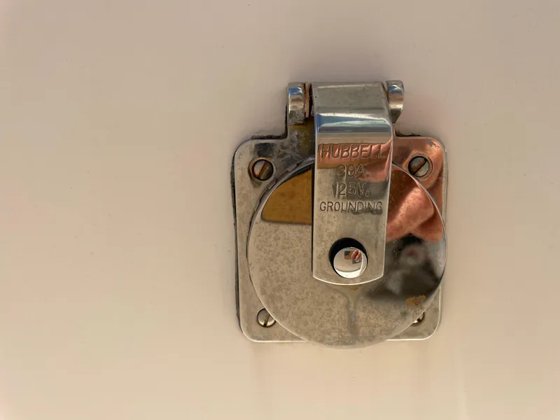 Slide: The Image of Stainless steel grounding port on a 2011 Pursuit 280 Center Console boat. - 48