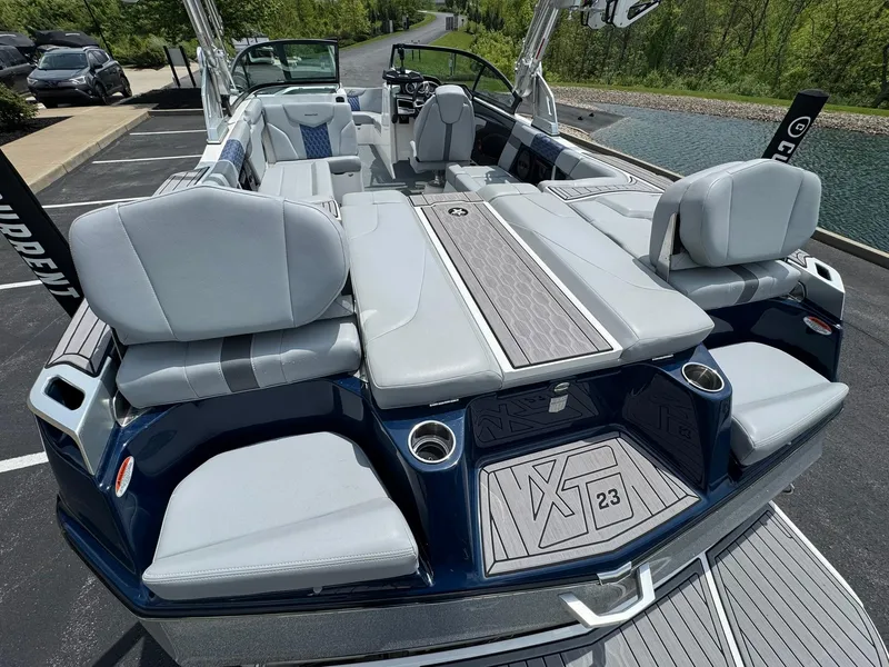 Slide: The Image of 2023 MasterCraft XT23 boat with sleek seating and modern design on a sunny day. - 15