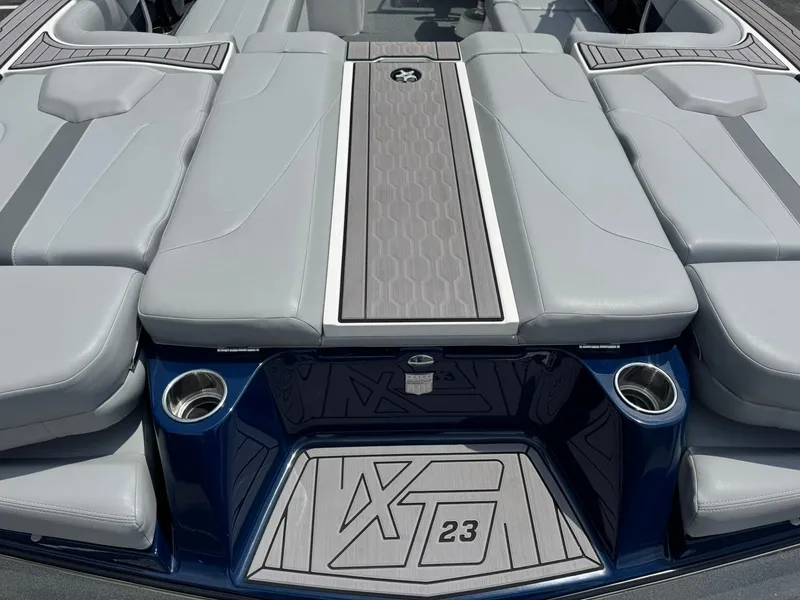 Slide: The Image of 2023 MasterCraft XT23 boat interior with sleek gray seating and stylish design elements. - 16