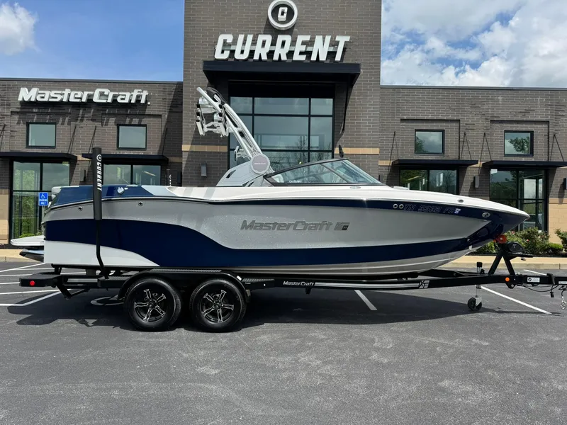 Slide: The Image of 2023 MasterCraft XT23 boat on trailer in front of dealership. - 3