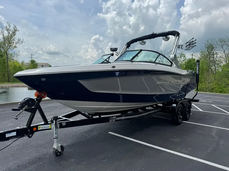Slide: The Image of 2023 MasterCraft XT23 boat on trailer in parking lot, under cloudy sky. - 7