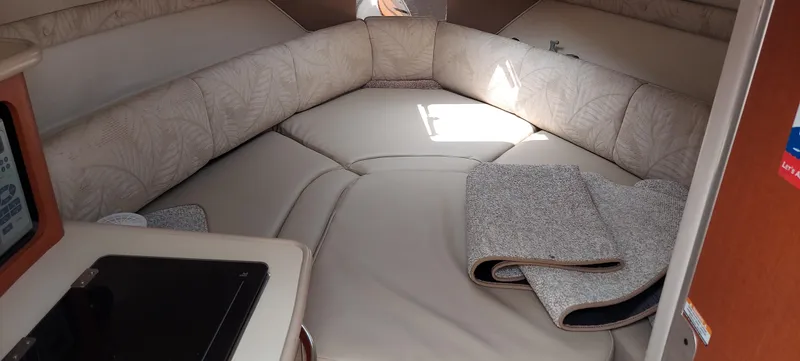 Slide: The Image of Interior cabin of a 2005 Chaparral Signature 240 boat with beige seating and folded blankets. - 10