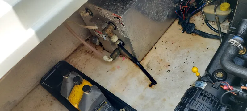 Slide: The Image of 2005 Chaparral Signature 240 engine compartment with oil containers and mechanical components. - 25