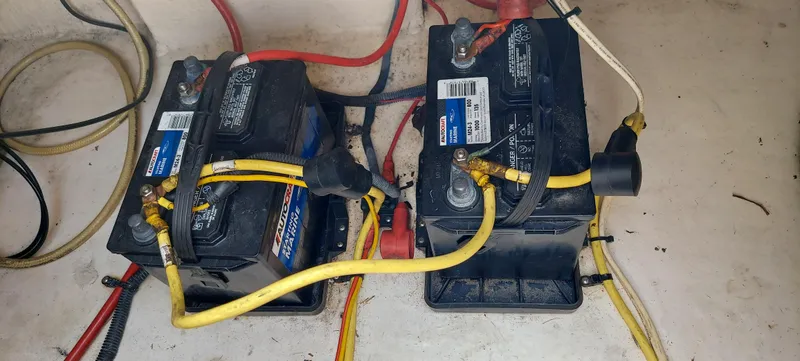 Slide: The Image of Two batteries in a 2005 Chaparral Signature 240 boat with connected cables. - 26