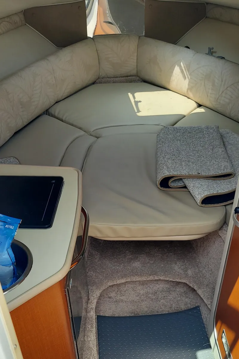 Slide: The Image of Interior cabin of a 2005 Chaparral Signature 240 boat with beige seating and a small table. - 32